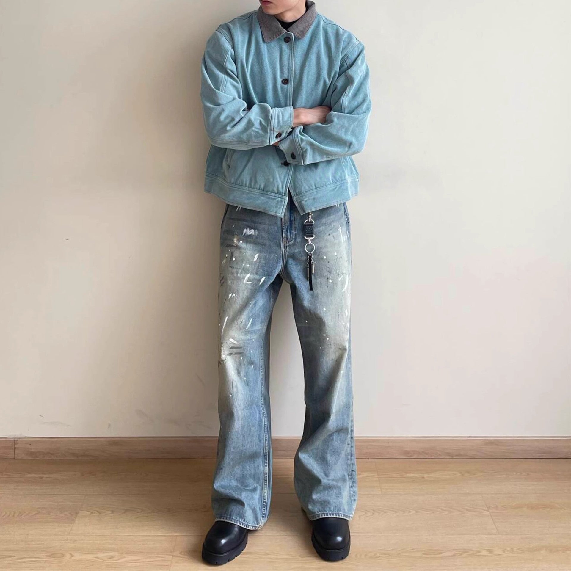 Calça jeans neutra de perna larga com estampa desgastada de respingos de tinta.